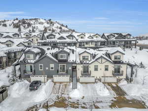 Snowy aerial view featuring a mountain view and a residential view