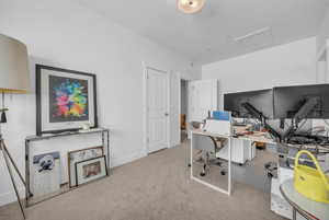 Home office with attic access and light carpet