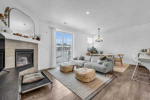 Living area with wood finished floors, a fireplace, recessed lighting, and a chandelier