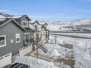 Exterior space with board and batten siding, stairs, an attached garage, and a mountain view