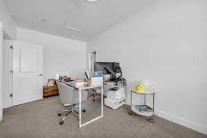 Home office featuring attic access and carpet flooring