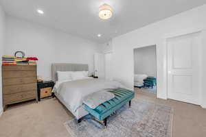 Bedroom featuring light colored carpet, attic access, and recessed lighting