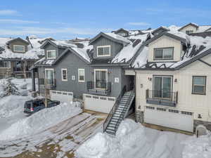 View of front of house featuring a garage and stone siding