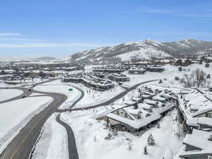 Snowy aerial view with a mountain view and a residential view