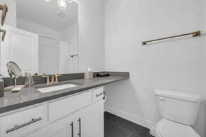 Bathroom with vanity, dark tile patterned flooring, and a shower with shower curtain