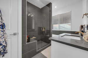 Bathroom with vanity, a shower stall, light tile patterned flooring, and recessed lighting