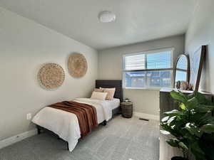 Carpeted bedroom with baseboards and a textured ceiling