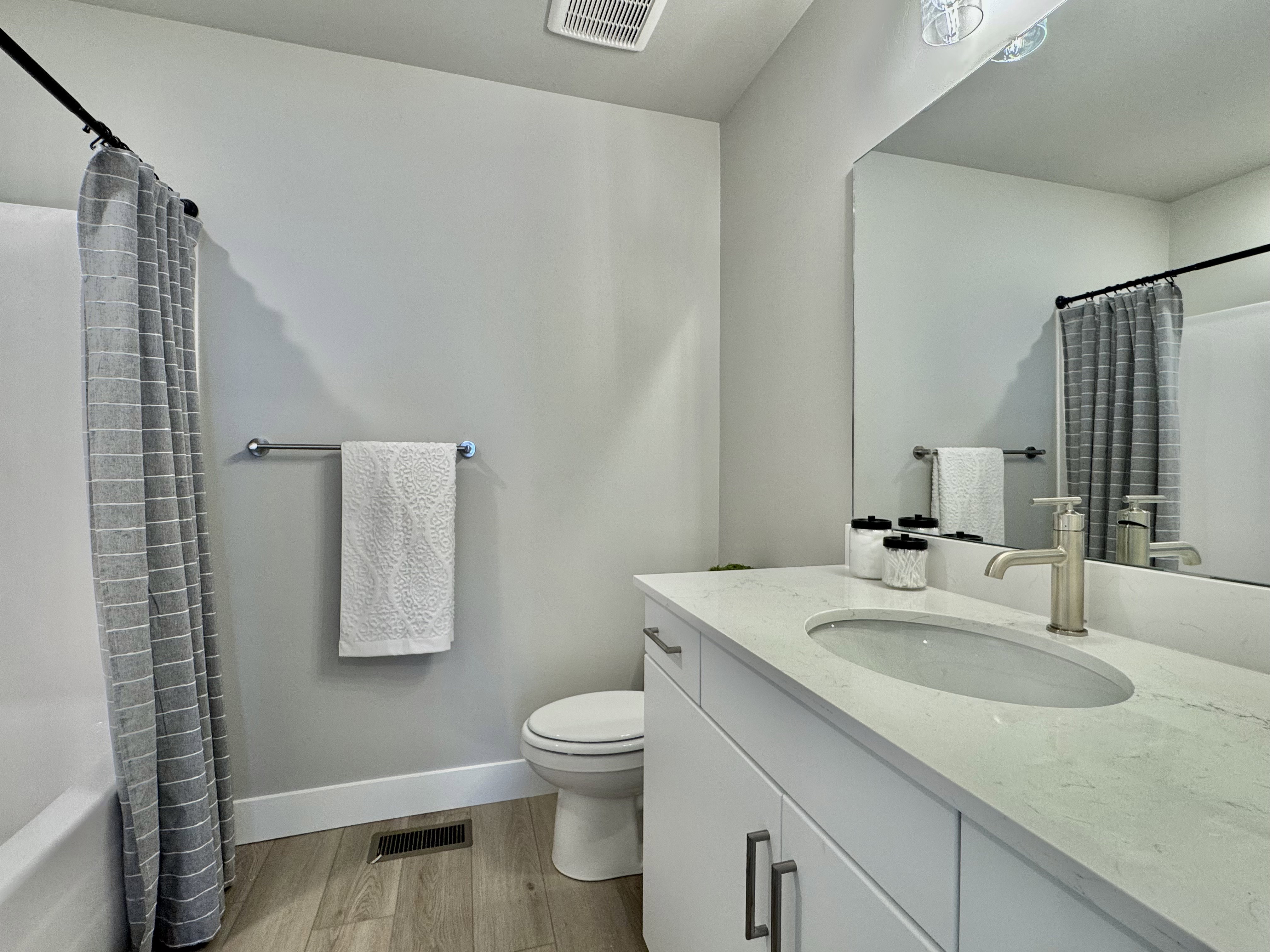 Full bath featuring light wood-style floors, vanity, and shower / bath combo