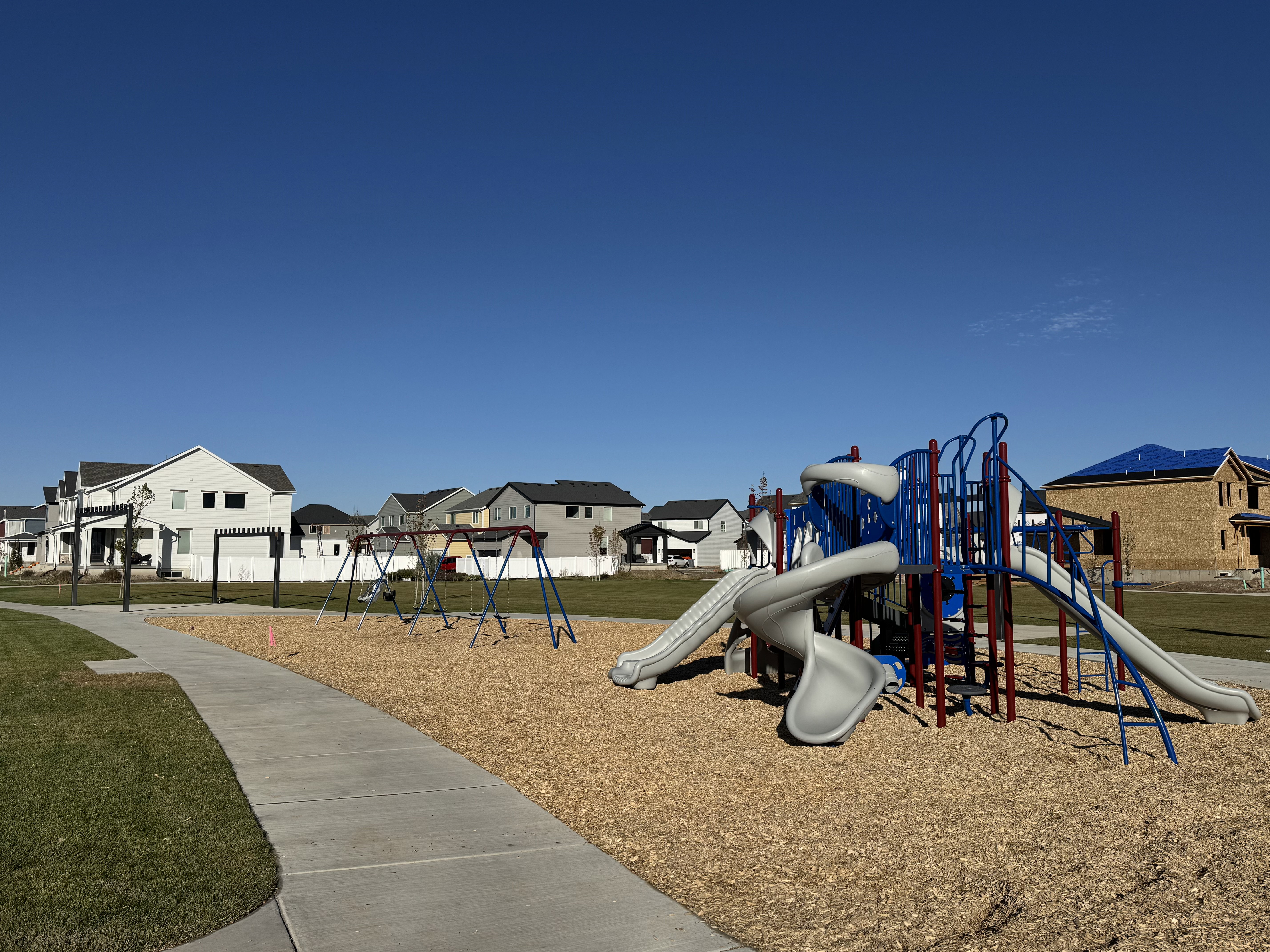 Community playground featuring a residential view and a lawn
