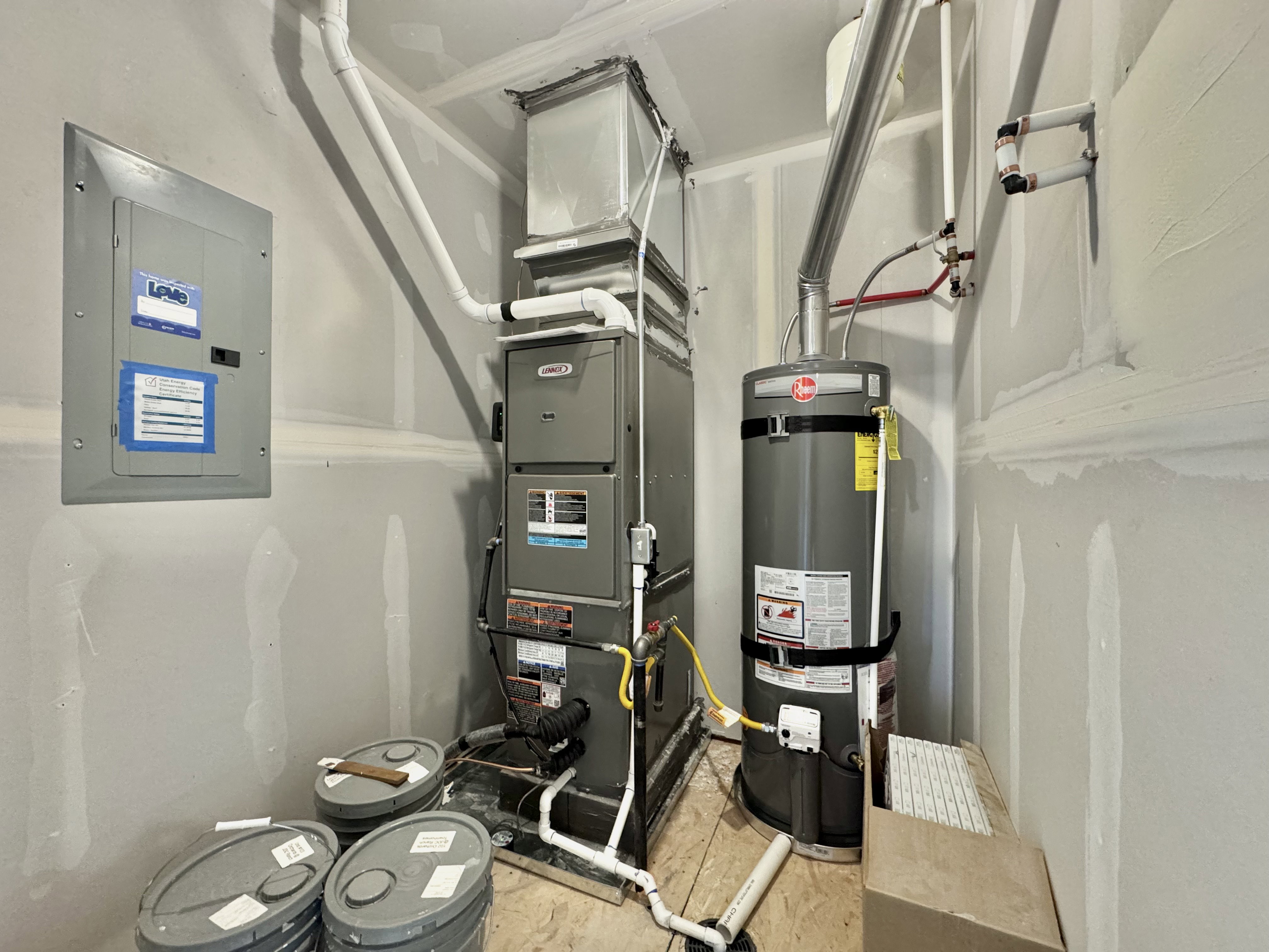 Utilities featuring electric panel, heating unit, and secured water heater