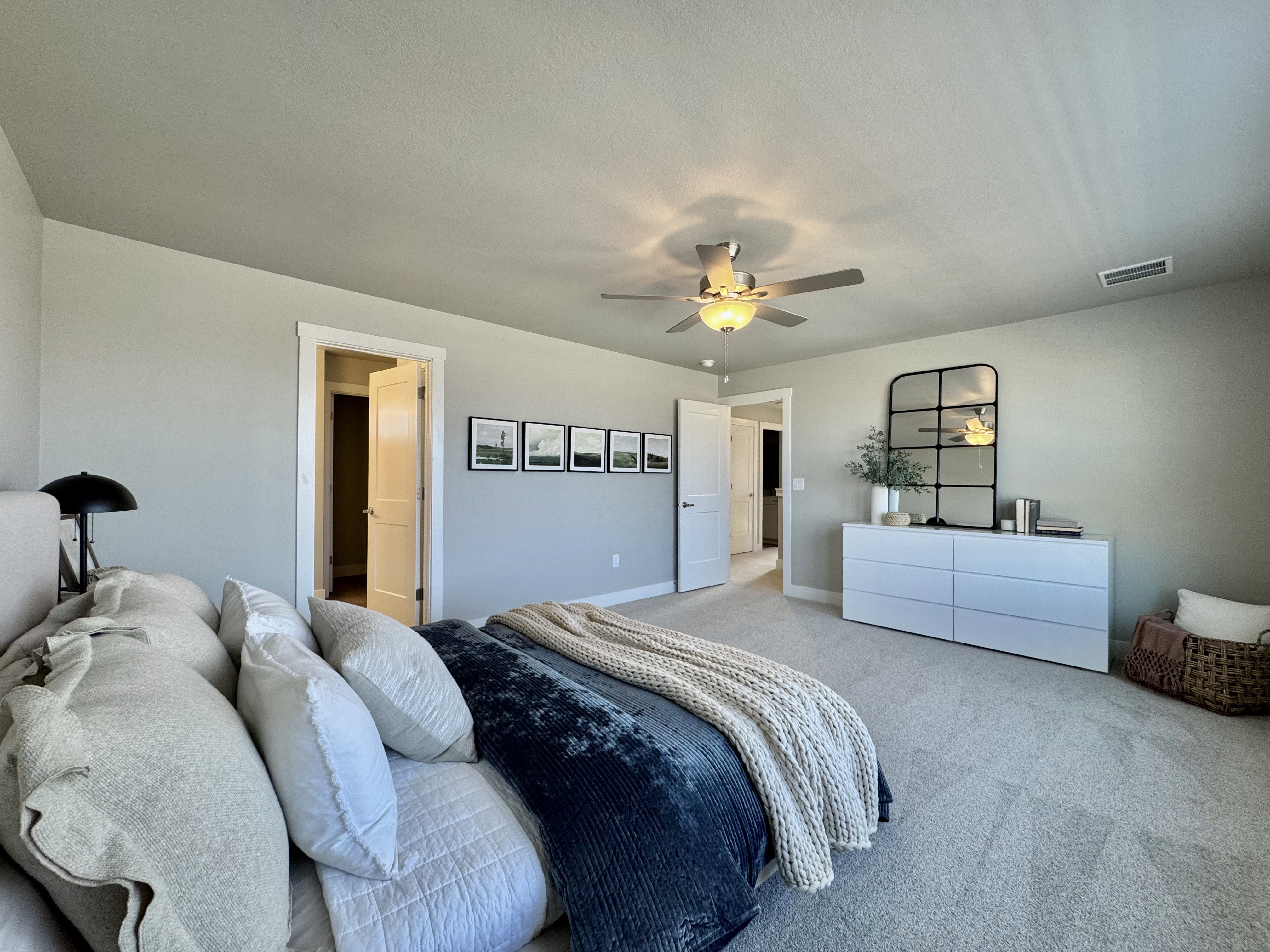 Carpeted bedroom with a ceiling fan and baseboards