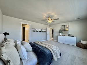 Carpeted bedroom with a ceiling fan and baseboards