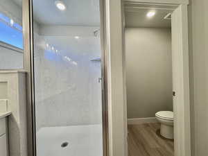 Bathroom with a stall shower, light wood-type flooring, and recessed lighting