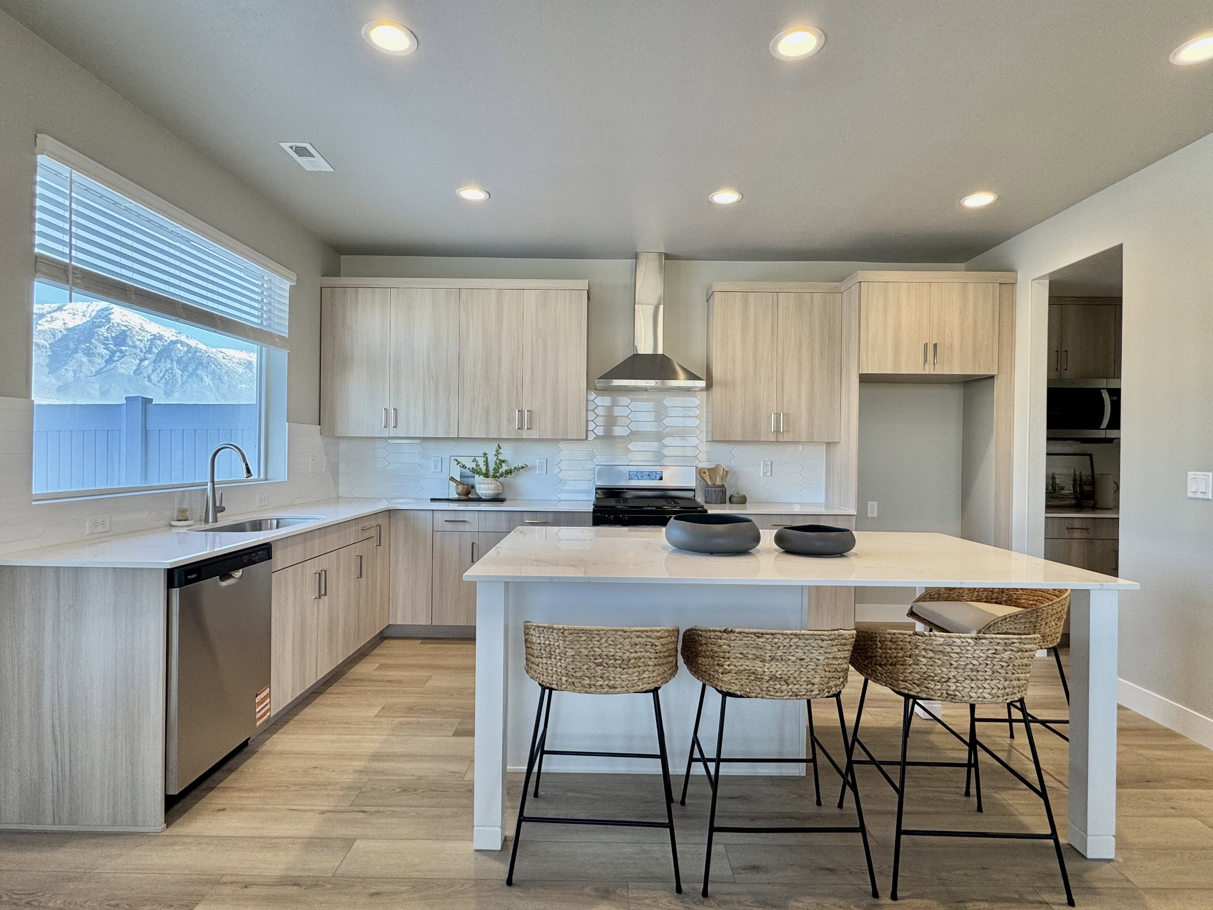 Kitchen featuring light brown cabinets, modern cabinets, light stone countertops, stainless steel appliances, and recessed lighting