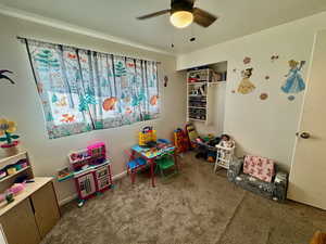 Game room with carpet floors and ceiling fan