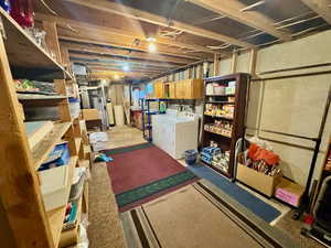 Unfinished basement featuring independent washer and dryer and water heater