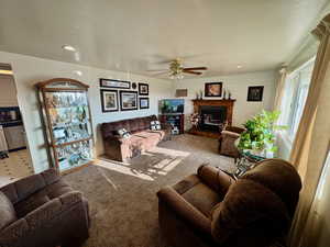 Carpeted living area featuring ceiling fan, recessed lighting, a glass covered fireplace, and wooden walls