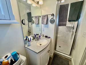 Bathroom featuring a marble finish shower and vanity