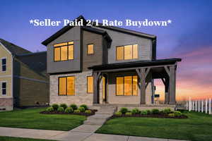 Contemporary home featuring a porch, stone siding, and a yard