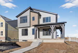 View of front of property featuring stone siding and covered porch