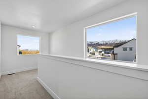 Corridor featuring light carpet and baseboards