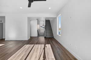 Unfurnished living room featuring stairway, dark wood finished floors, ceiling fan, and recessed lighting