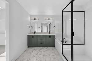Bathroom featuring a garden tub, light marble finish flooring, double vanity, and a stall shower