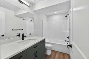 Full bathroom featuring vanity, shower / washtub combination, and dark wood-type flooring
