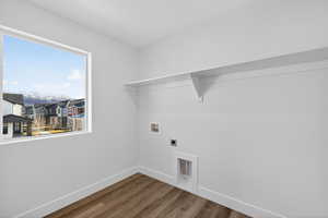 Washroom featuring dark wood-style flooring, hookup for a washing machine, and hookup for an electric dryer