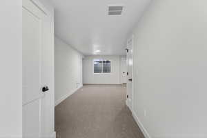 Hallway featuring baseboards and carpet floors