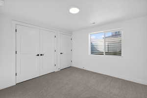 Unfurnished bedroom with carpet and a closet
