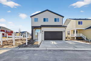 View of front of house featuring driveway, an attached garage, and a residential view