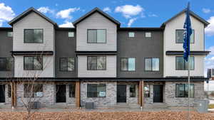 Rear view of house featuring brick siding and stucco siding
