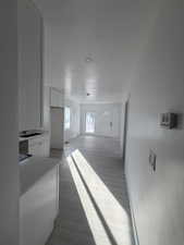 Corridor with dark wood-type flooring and baseboards