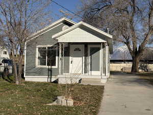 View of front of property featuring a porch and concrete driveway