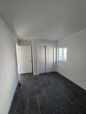 Unfurnished bedroom with a closet and baseboards