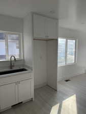 Kitchen with white cabinetry and light wood-style flooring