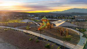 Playground at dusk featuring a mountain view and a residential view