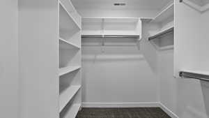 Walk in closet featuring dark carpet
