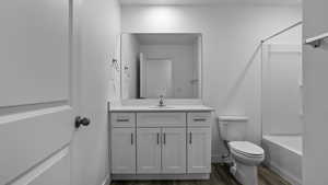 Full bath with vanity, bathing tub / shower combination, and dark wood-type flooring