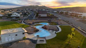 Aerial view of residential area with a mountain backdrop and a community park