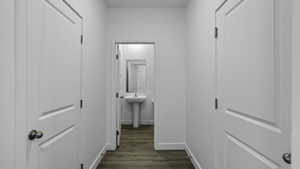 Hall with dark wood-style flooring and a sink