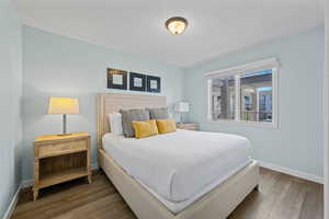 Bedroom with hardwood / wood-style floors and a textured ceiling