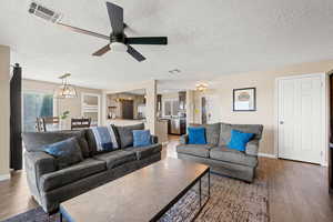 Living area with a textured ceiling, hardwood / wood-style flooring, and ceiling fan