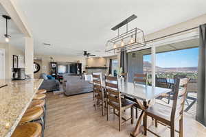 Dining space with ceiling fan, light wood-type flooring, and a textured ceiling