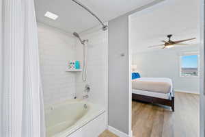 Bathroom with shower / bath combo, connected bathroom, a textured ceiling, ceiling fan, and light wood-style floors
