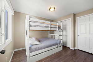 Bedroom with dark wood finished floors, a closet, and a textured ceiling