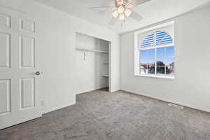 Unfurnished bedroom featuring a closet, carpet flooring, ceiling fan, and a textured ceiling