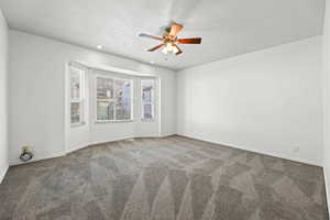 Empty room featuring a textured ceiling, carpet floors, ceiling fan, and recessed lighting