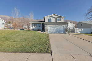 View of front of home with covered porch, concrete driveway, a garage, and a gate